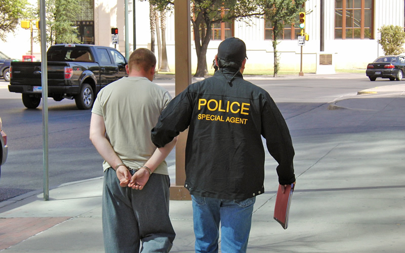 An ICE HSI special agent escorts 23-year-old U.S. soldier following his arrest on child pornography charges
